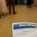 The U.S. has added jobs in every month for nearly eight years. Here, a job seeker holds an employment flier during a hiring event at an Aldi Supermarket in Darien, Ill., in July.