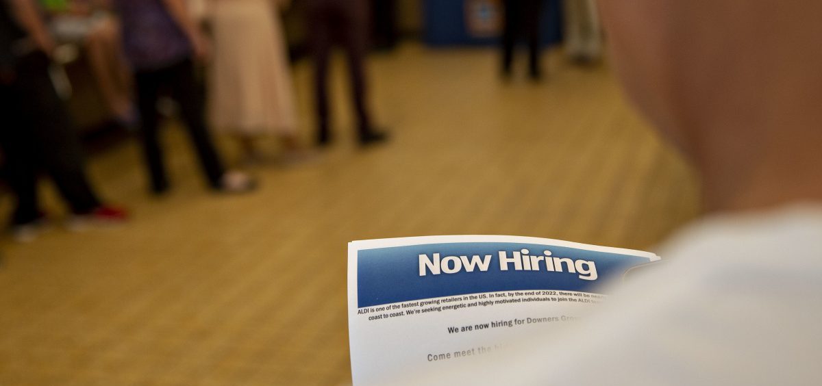 The U.S. has added jobs in every month for nearly eight years. Here, a job seeker holds an employment flier during a hiring event at an Aldi Supermarket in Darien, Ill., in July.