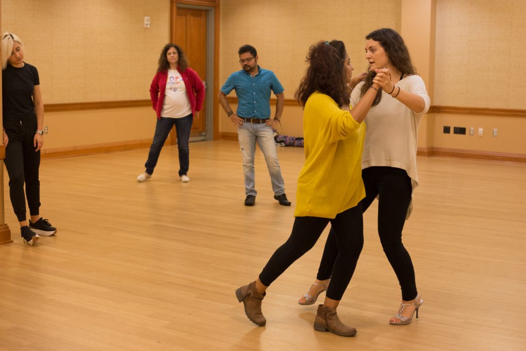 Tango Club instructor Maria Casa (left) leads Namrata Jain in the back ocho while Tanya Tytko (from left), Tracy Shust, and Dibya Ghosh watch their movements in Baker Student Center at Ohio University on Thursday, October 11, 2018. (Hannah Schroeder/ WOUB)