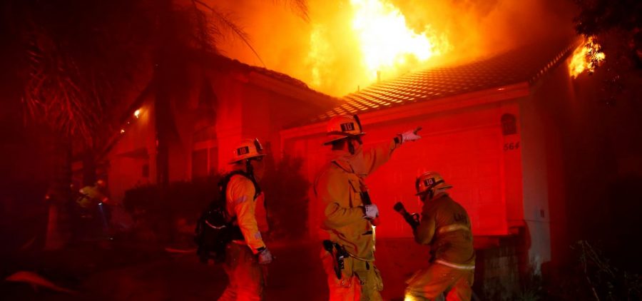 Firefighters try to beat back the Woolsey Fire in the early hours of Friday. One day earlier, the blaze ignited as mourning residents tried to cope with quite another kind of terror in Thousand Oaks, Calif.