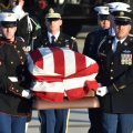 The flag-draped casket of former President George H.W. Bush is carried by a joint services military honor guard to the hearse at Joint Base Andrews, Md., on Monday.
