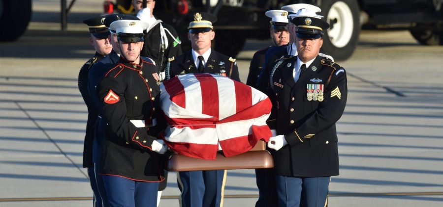 The flag-draped casket of former President George H.W. Bush is carried by a joint services military honor guard to the hearse at Joint Base Andrews, Md., on Monday.