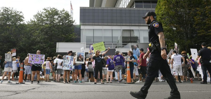 In this Aug. 17, 2018 file photo, family and friends who have lost loved ones to OxyContin and opioid overdoses protest outside Purdue Pharma headquarters in Stamford, Conn.