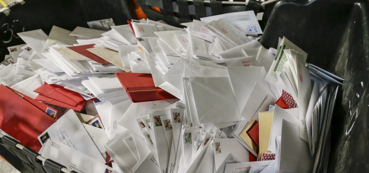 Letters wait in bins for sorting at the main post office in Omaha, Neb. The price of a Forever Stamp has increased 10 percent as the U.S. Postal Service contends with billions of dollars in annual losses.