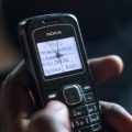 A poor resident of a village in Kenya checks his phone to confirm that a cash transfer has been made.