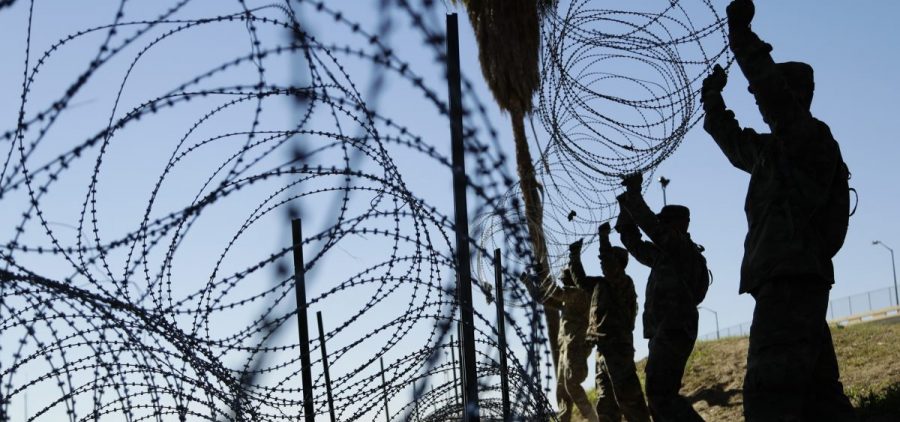 Members of the U.S. military install multiple tiers of concertina wire along the banks of the Rio Grande near the Juarez-Lincoln Bridge at the U.S.-Mexico border in Laredo, Texas, in November.