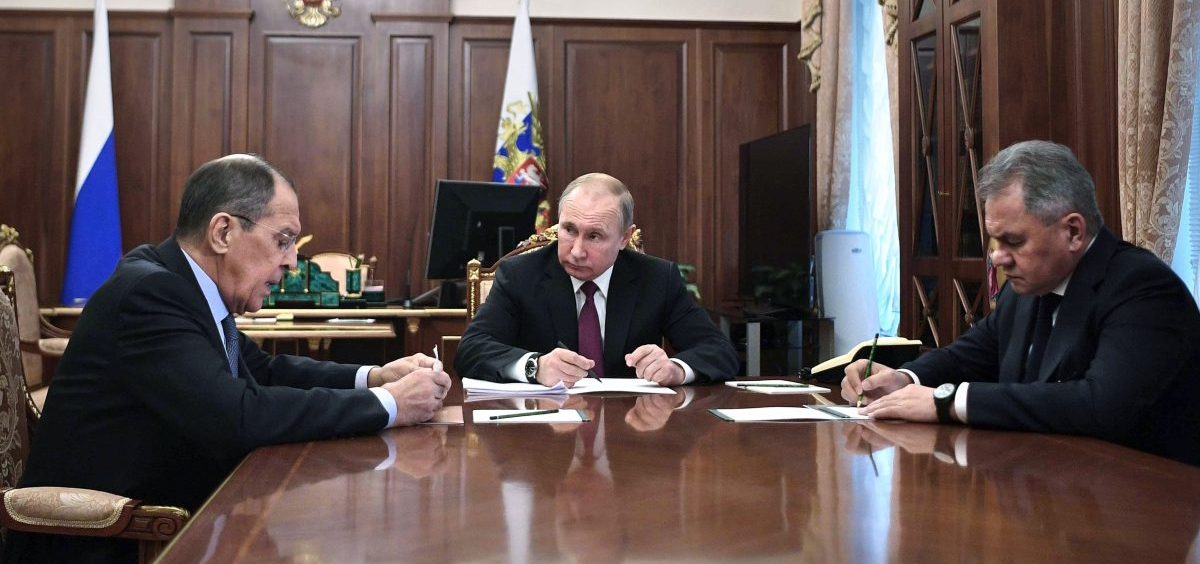 Russian President Vladimir Putin (center) attends a meeting with Russian Foreign Minister Sergey Lavrov (left) and Defense Minister Sergei Shoigu in the Kremlin in Moscow on Saturday. Putin said Russia would abandon the 1987 Intermediate-Range Nuclear Forces treaty, calling it a "symmetrical" response to the U.S. decision to withdraw.