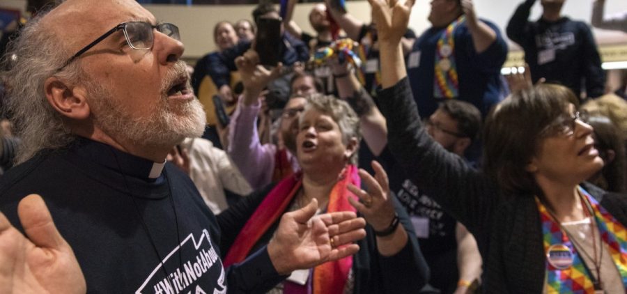Protesters sing and pray outside the United Methodist Church's special session of the general conference in St. Louis on Tuesday. Delegates voted to maintain current rules against LGBTQ clergy and same-sex marriage.