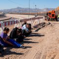 Salvadoran migrants wait for transportation after turning themselves in to U.S. Border Patrol agents in El Paso, Texas — where a border fence is under construction. The Pentagon says it will spend up to $1 billion to help build the fence.