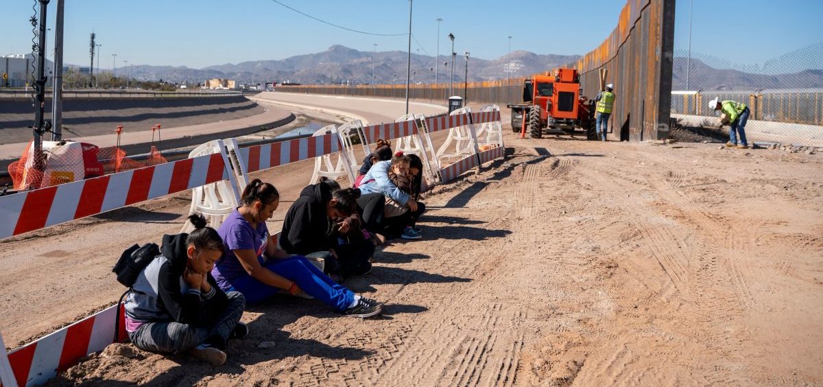 Salvadoran migrants wait for transportation after turning themselves in to U.S. Border Patrol agents in El Paso, Texas — where a border fence is under construction. The Pentagon says it will spend up to $1 billion to help build the fence.