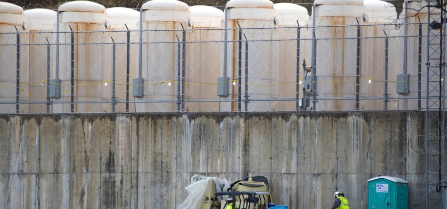 Once it is safe to remove the spent fuel from the pool, it's stored outside in white, metal casks. They are lined up on a concrete base behind razor wire, against a hillside near the power plant.