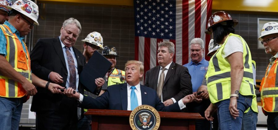 President Trump hands out pens after signing an executive order aimed at making it easier for companies to pursue oil and gas pipeline projects. The president addressed an audience at the International Union of Operating Engineers International Training and Education Center in Texas.