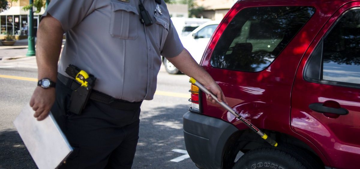 A traffic enforcement officer chalks tires in Arvada, Colo., in 2014. Physically marking a tire without a warrant is a violation of the Fourth Amendment, a federal appeals court ruled.
