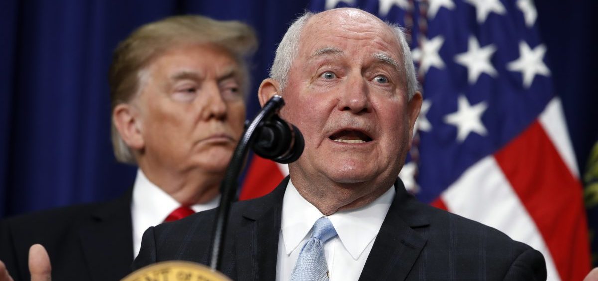 President Trump listens to Agriculture Secretary Sonny Perdue during a signing ceremony. The USDA wants to move two vital research agencies out of Washington D.C.