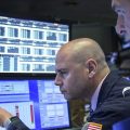 Traders and financial professionals work on the floor of the New York Stock Exchange on Monday. U.S. stock markets fell sharply at the open but crept higher as the day wore on after President Trump threatened to raise tariffs on imports from China.