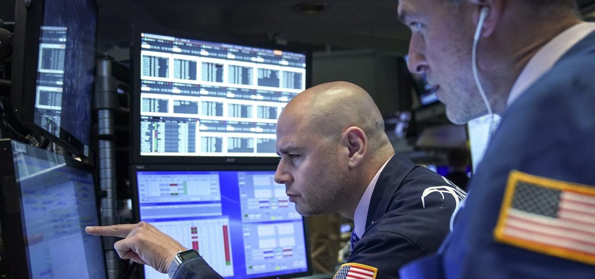 Traders and financial professionals work on the floor of the New York Stock Exchange on Monday. U.S. stock markets fell sharply at the open but crept higher as the day wore on after President Trump threatened to raise tariffs on imports from China.