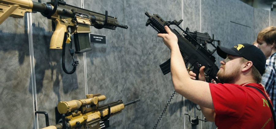 A visitor peruses H&K rifles at the SHOT Show in Las Vegas. Such weapons were once restricted under a 1994 ban that expired with changing politics in the United States.