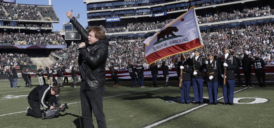 In this Dec. 24, 2016 file photo, Eddie Money performs the national anthem before an NFL football game between the Oakland Raiders and the Indianapolis Colts in Oakland, Calif.