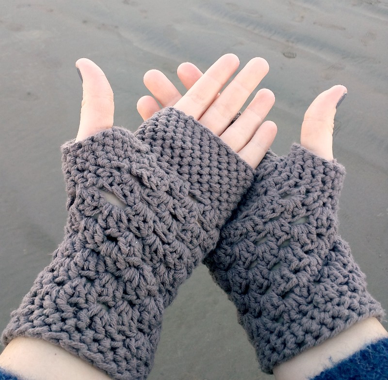 Two hands display gloves made using crochet techniques