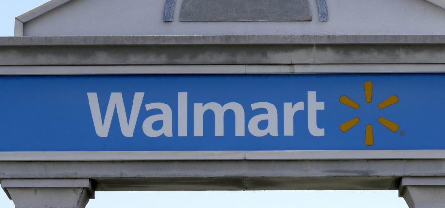A Walmart logo forms part of a sign outside a Walmart store, Tuesday, Sept. 3, 2019, in Walpole, Mass. Walmart is going back to its folksy hunting heritage and getting rid of anything that's not related to a hunting rifle after a mass shooting this summer.