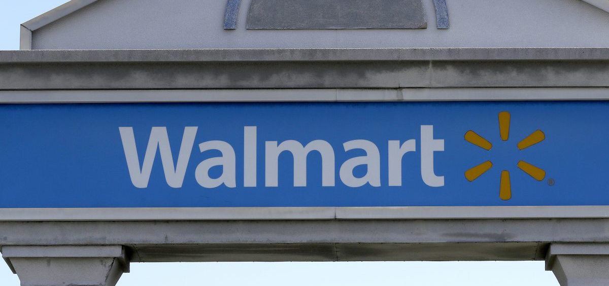 A Walmart logo forms part of a sign outside a Walmart store, Tuesday, Sept. 3, 2019, in Walpole, Mass. Walmart is going back to its folksy hunting heritage and getting rid of anything that's not related to a hunting rifle after a mass shooting this summer.