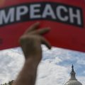 A protester holds up a sign in favor of impeachment outside the U.S. Capitol building on Thursday.