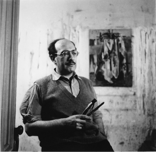 Mark Rothko holding brushes in front of work on paper