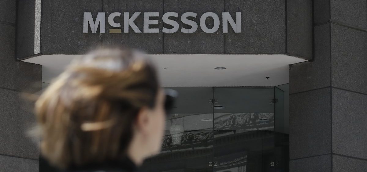 A pedestrian passes a McKesson sign on an office building in San Francisco.