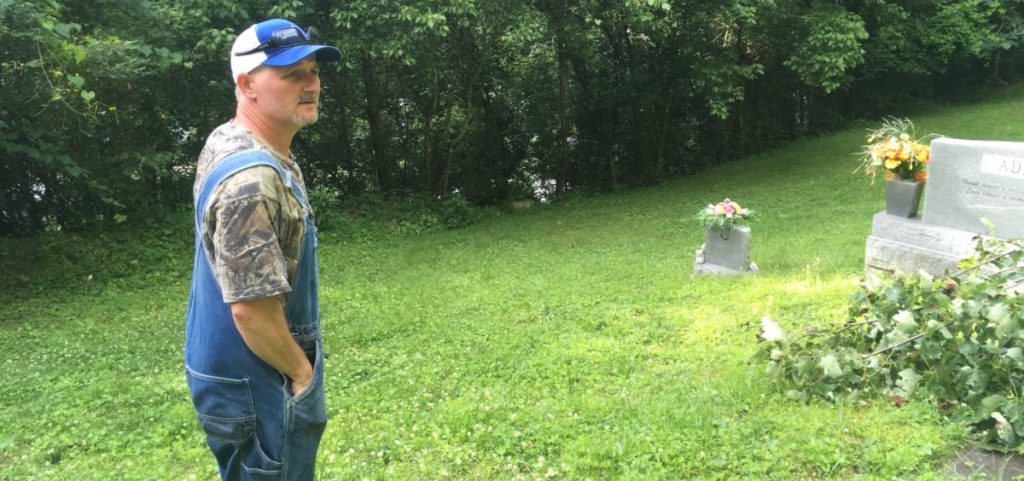 Todd Bentley stands in his family cemetery in Harless Creek in June, recalling the night of the 2010 flood. Bentley spent the night here with his teenage son when the creek swelled too high to cross safely.