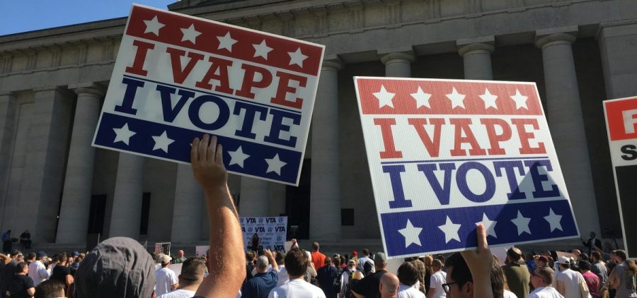 People hold signs that read "I Vape, I Vote" outside the Ohio Statehouse