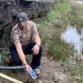 Jasper Davis gets drinking water from a mountain stream in Martin County, Ky. He says he's one of many in the struggling coal region who have trouble affording their water bill.