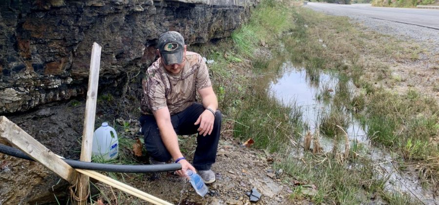 Jasper Davis gets drinking water from a mountain stream in Martin County, Ky. He says he's one of many in the struggling coal region who have trouble affording their water bill.