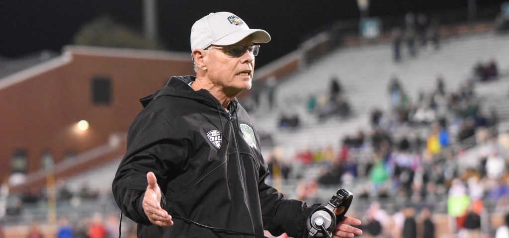 Ohio Football Frank Solich stands on the sidelines with his arms out like he's asking a question.