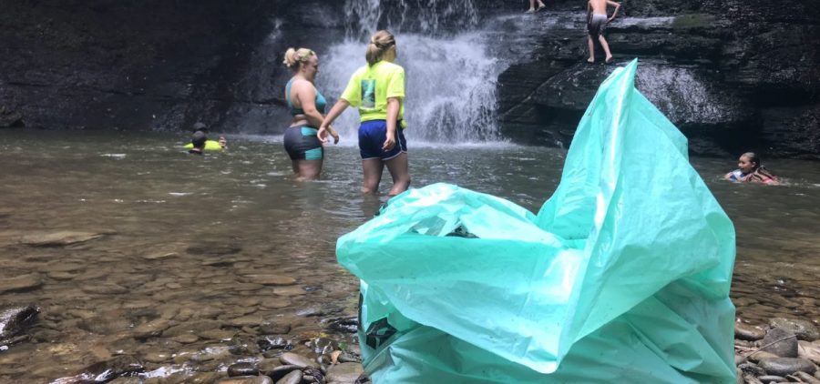 Volunteers swim in Peachtree Falls after cleaning up trash in the nearby creek.