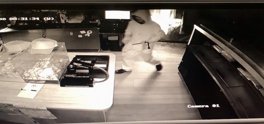 Black and white photo from surveillance video of a person inside of a restaurant