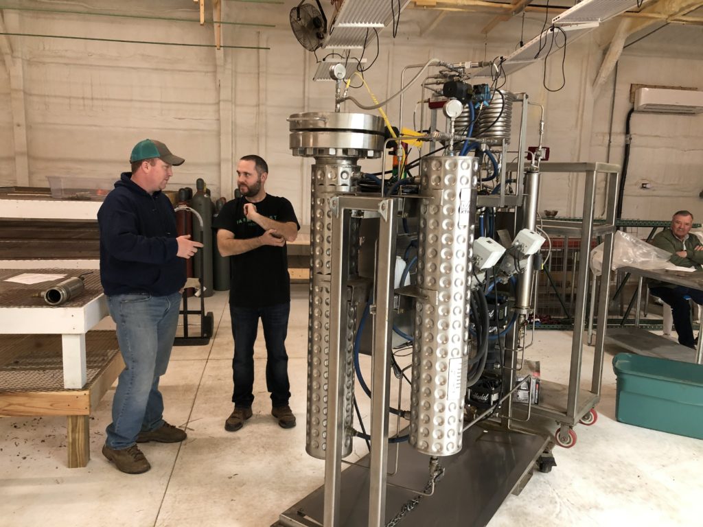 Huff (left) and Fuller (right), next to a small hemp processing machine.
