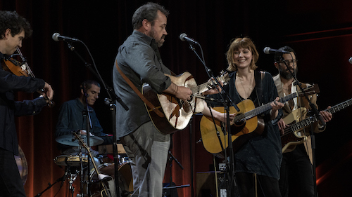 Dan Tyminski, singer of the iconic “Man of Constant Sorrow” from the Coen Brothers’ classic film, O! Brother Where Art Thou (center on guitar), joins guitar prodigy Molly Tuttle on Townes van Zandt’s classic, “White Freightliner Blues.”