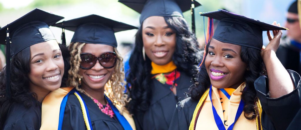 African American college graduates in academic gowns