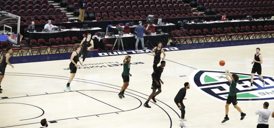 Ohio University basketball players warm up in an empty arena without fans before an NCAA college basketball game against Akron in the Mid-American Conference men's tournament, Thursday, March 12, 2020, in Cleveland..
