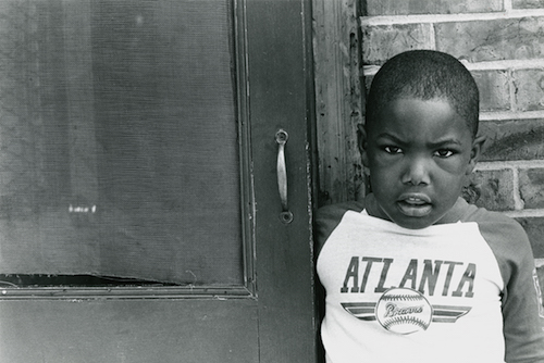 Brandon Thrasher stands in front of East Lake apartment. Atlanta, GA. Circa 1990.