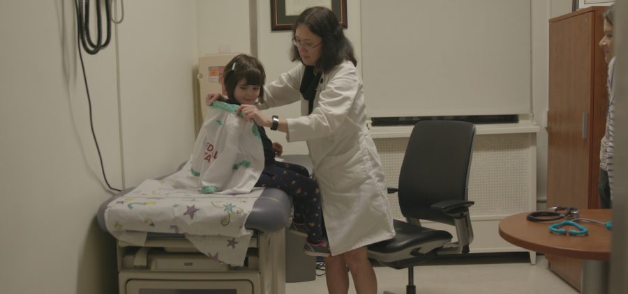 dr. putting jacket on child in waiting room