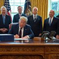 President Trump signs the CARES act, a $2 trillion rescue package to provide economic relief amid the coronavirus outbreak, at the Oval Office of the White House on Friday.