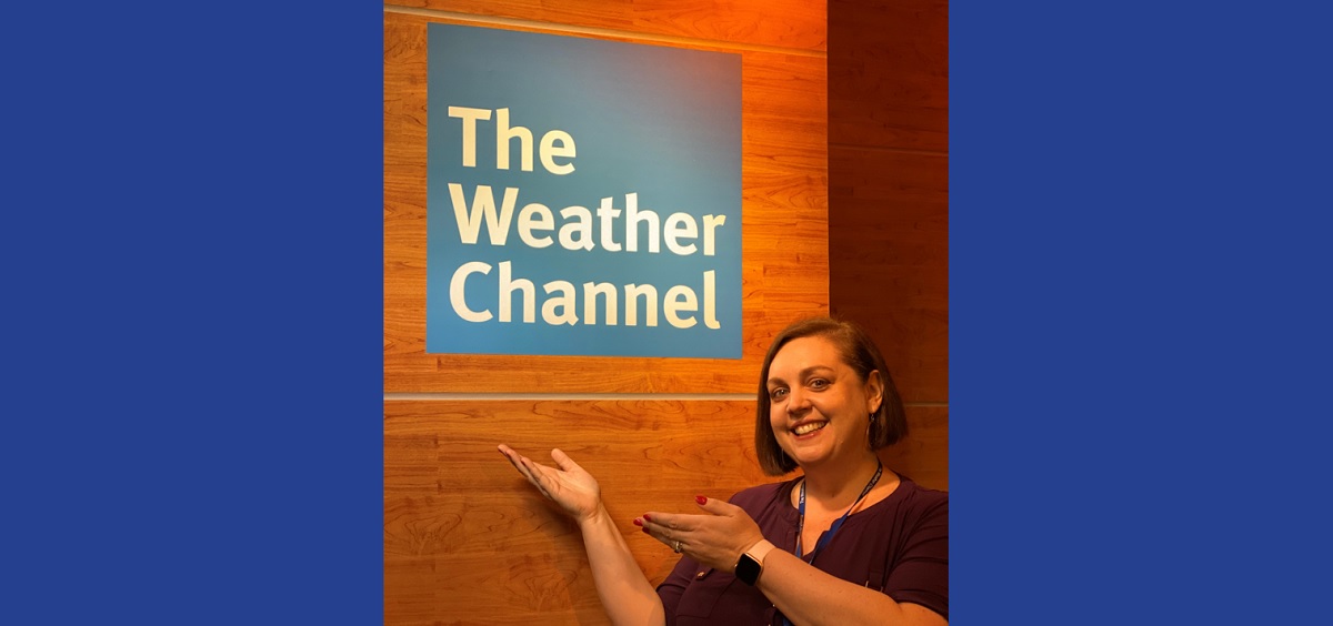 Angie Massie in front of Weather Channel sign