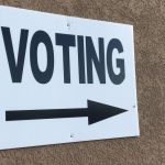 A voting sign points into a polling location
