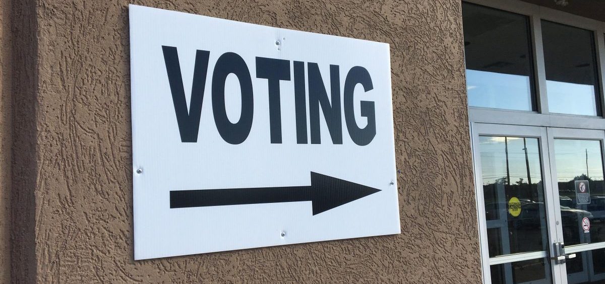 A voting sign points into a polling location
