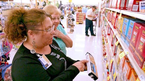 Shoppers looking at dietary info on food box
