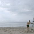 lone swimmer on beach at lifeguard stand