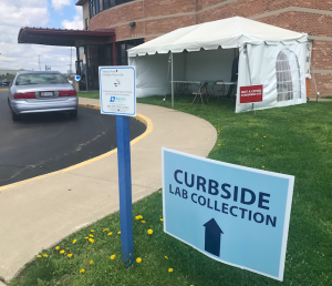 Picture of sign that directs people to curbside blood collection driveway 