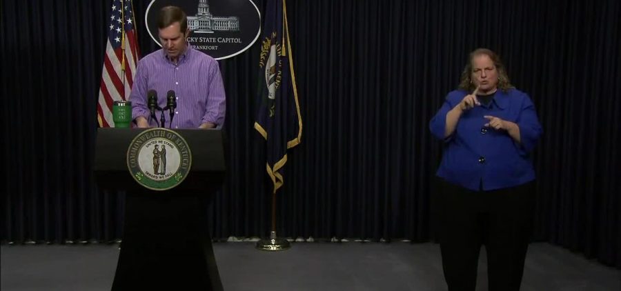 Gov of Kentucky at podium with sign language interpreter next to him