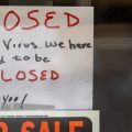 Signs are displayed in the window of a store in Grosse Pointe Woods, Mich. The Paycheck Protection Program, aimed at helping small businesses survive the coronavirus crisis, has been beset by problems.